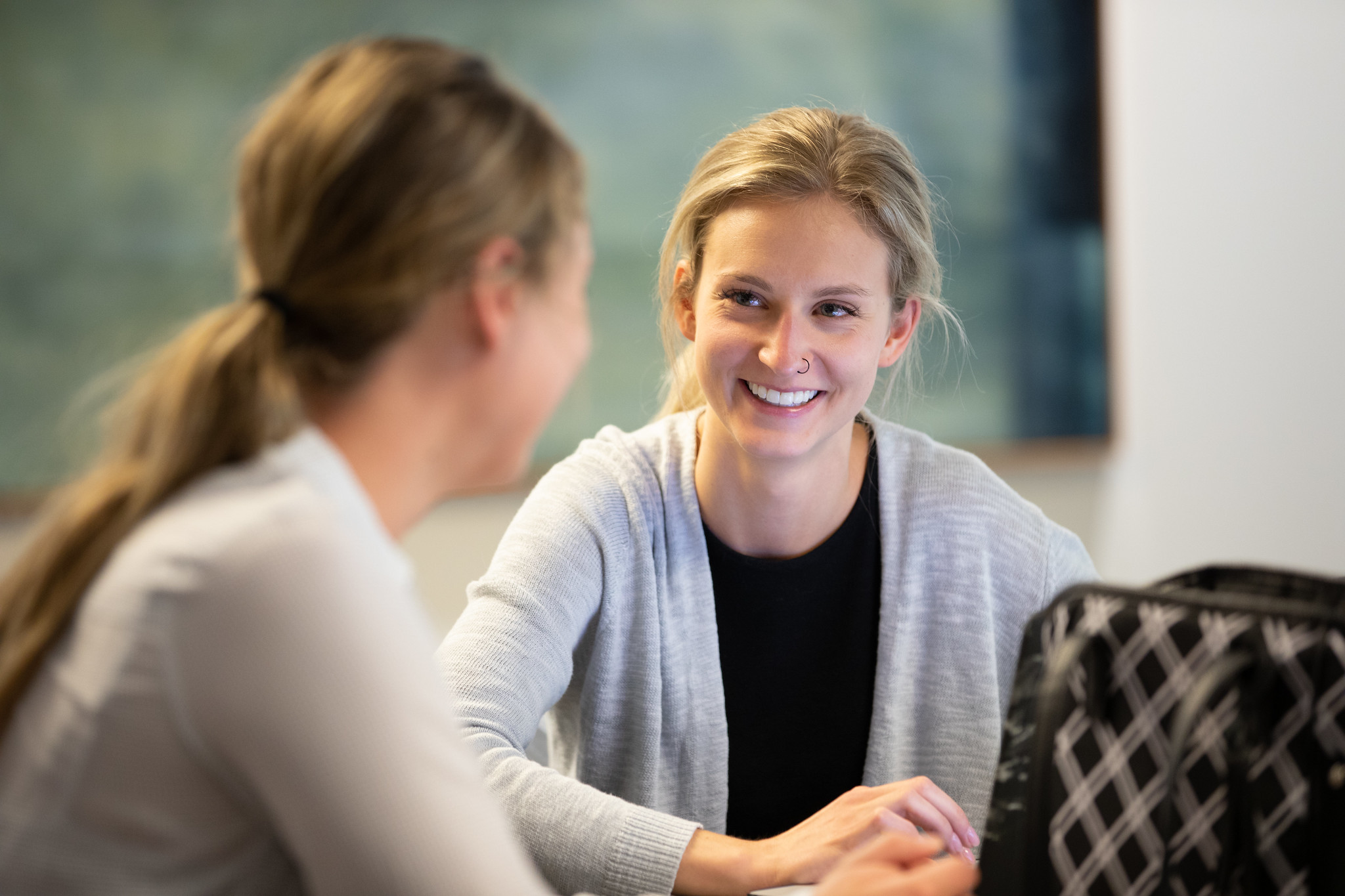 Two women facing each other studying at Bethel Seminary