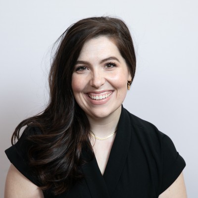 Smiling woman with long dark hair poses for a professional headshot.